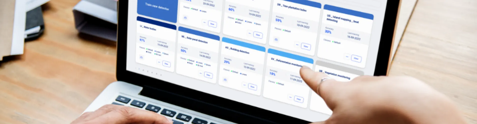 Person pointing at Picterra platform on laptop screen for model training and analysis