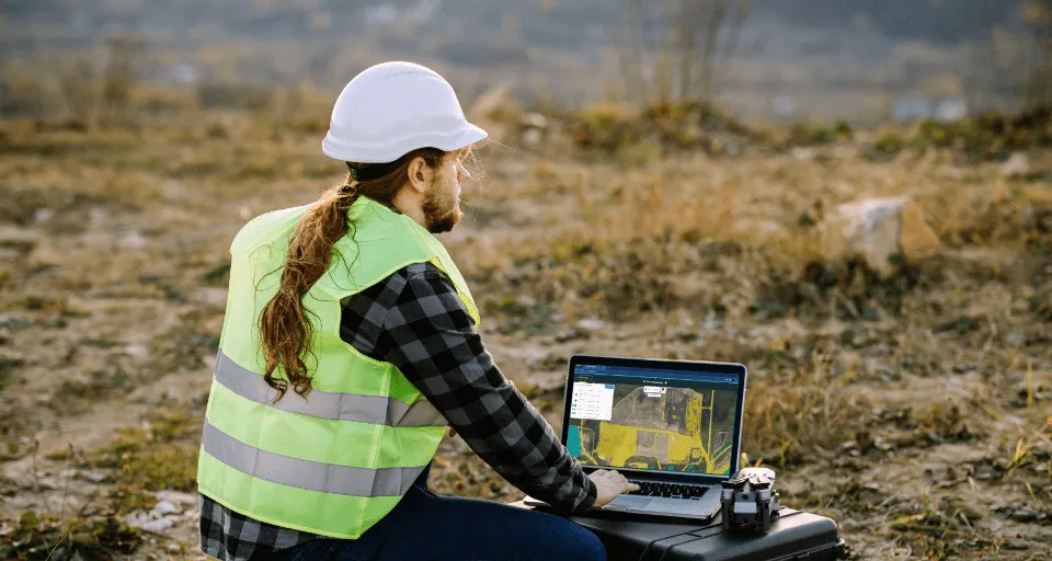 Photograph of someone using Picterra on a laptop in a mining site