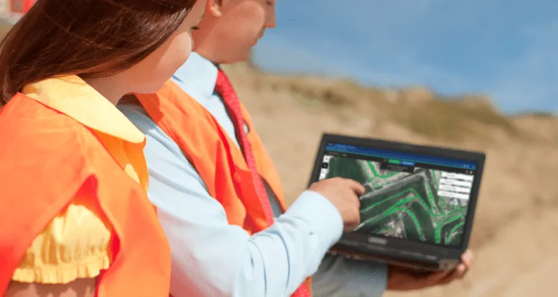Screenshot of two people using Picterra on a laptop in a mining site