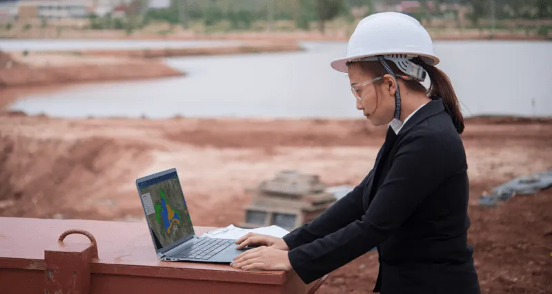 Photograph of a person using Picterra on a laptop in a mining site